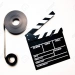 Two 35mm movie reels and clapperboard in vintage color effect