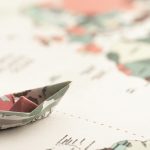 high-angle-small-origami-boat-on-world-map