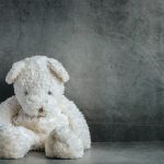 Teddy bear sad in an empty room, national child abuse prevention