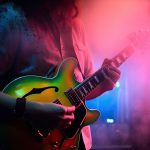 guitarist playing the guitar in a concert illuminated with neon lights. Ai generative