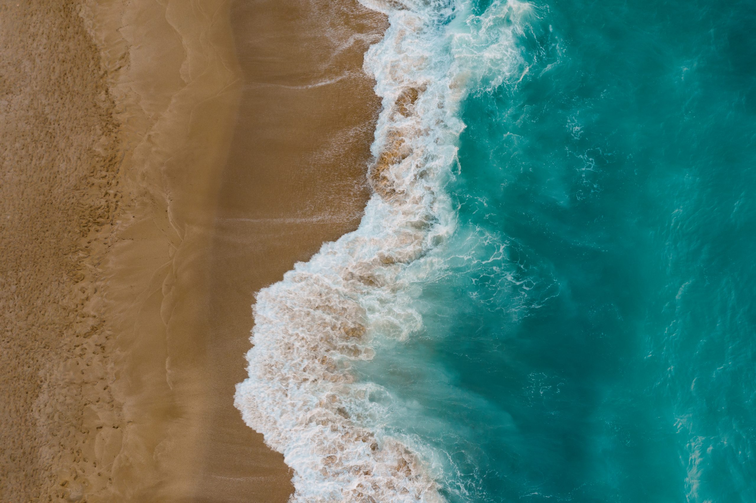 Top view of sand meeting seawater