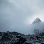 Breathtaking view of the snowy mountain summit in a foggy weather