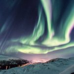 Vertical shot of a night winter landscape with Northern lights reflection on the river